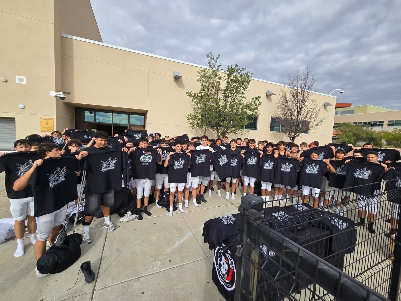 Cleveland Hawks football team holding up sponsored Unleashed shirts